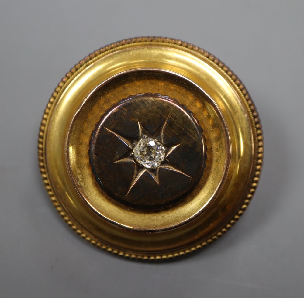 A Victorian yellow metal and diamond set circular brooch, with glazed back, 32mm, gross 10.3 grams.